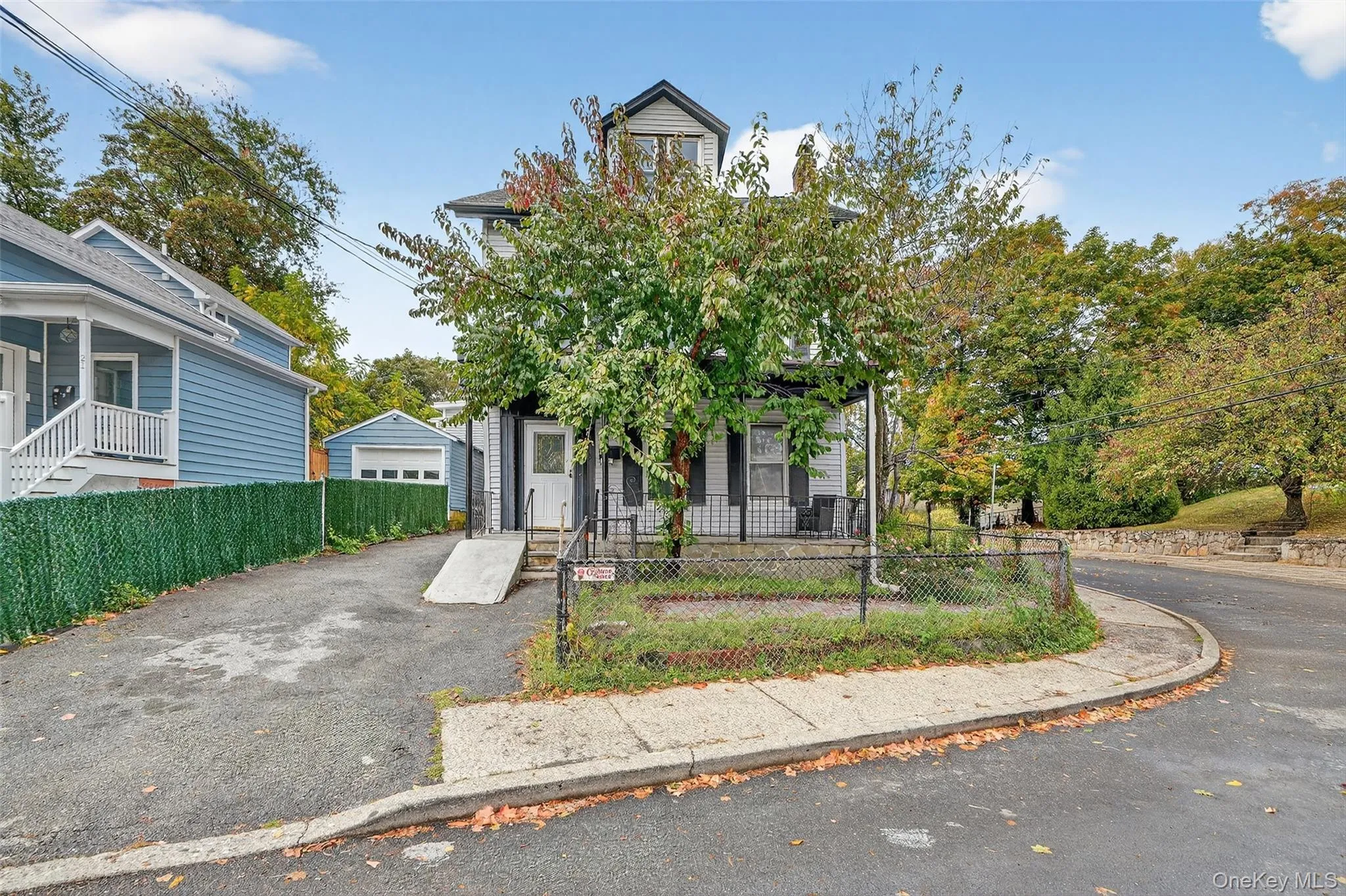 View of front facade featuring a fenced front yard, a garage, and driveway View of front facade featuring a fenced front yard, a garage, and driveway