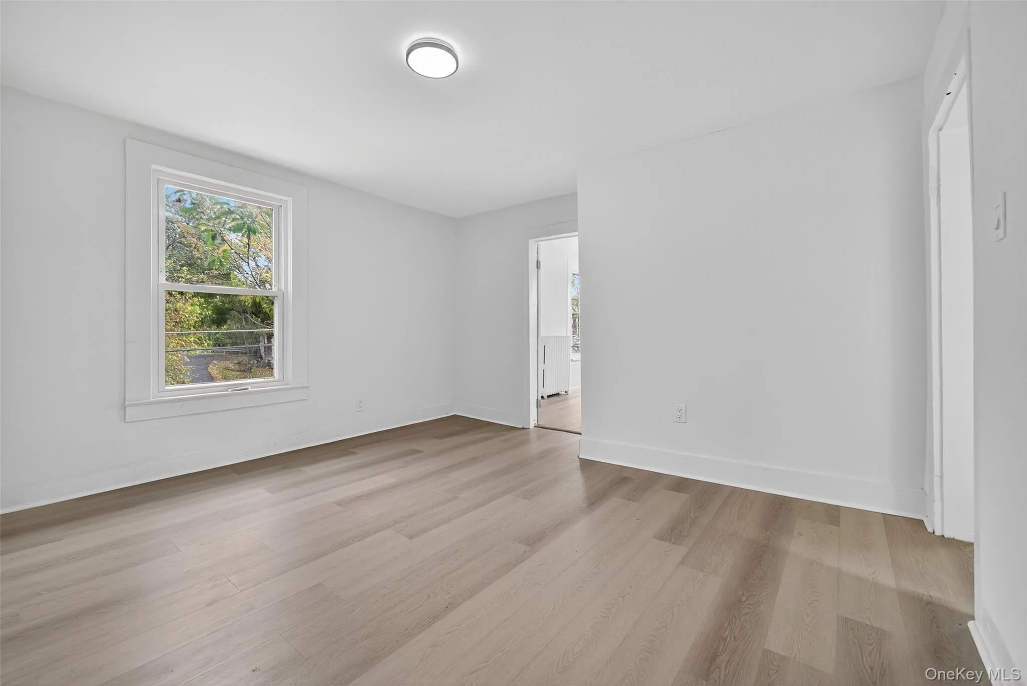 Empty room with light wood finished floors and baseboards Empty room with light wood finished floors and baseboards