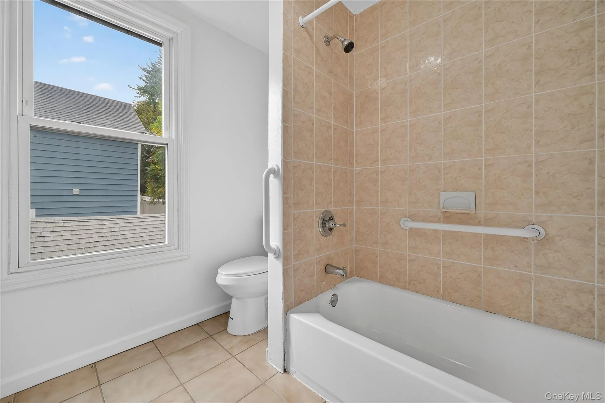Bathroom featuring tile patterned floors and shower / tub combination Bathroom featuring tile patterned floors and shower / tub combination