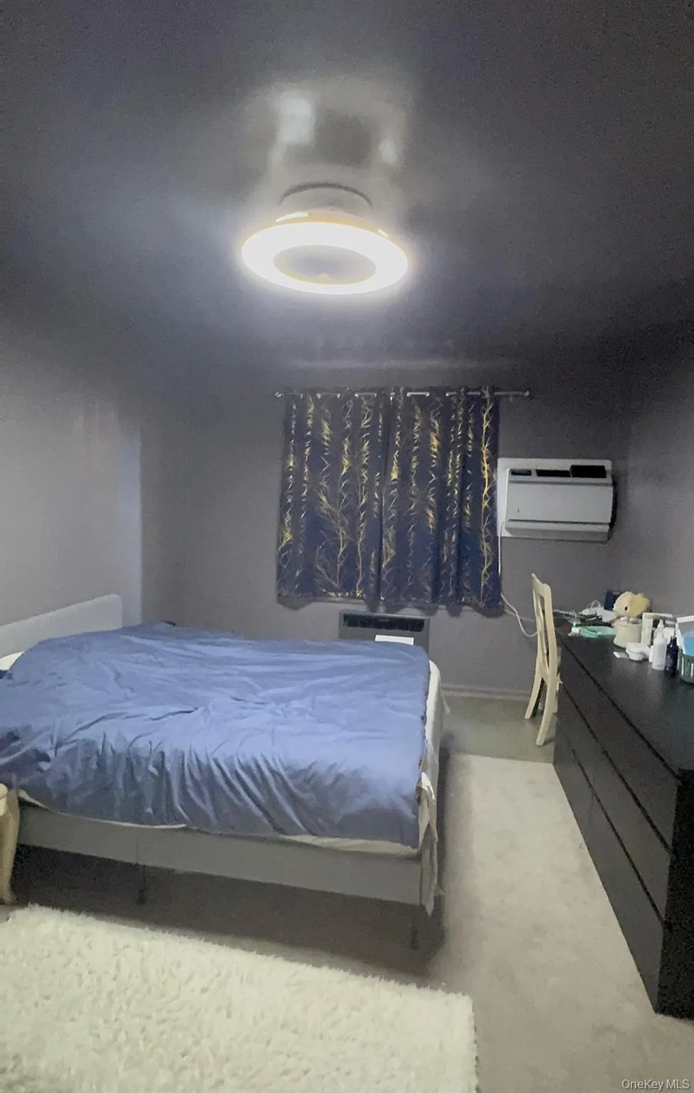 Bedroom featuring an AC wall unit and carpet floors Bedroom featuring an AC wall unit and carpet floors