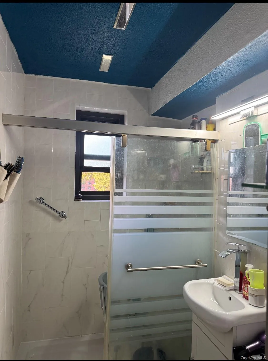 Bathroom with vanity, a stall shower, and a textured ceiling Bathroom with vanity, a stall shower, and a textured ceiling