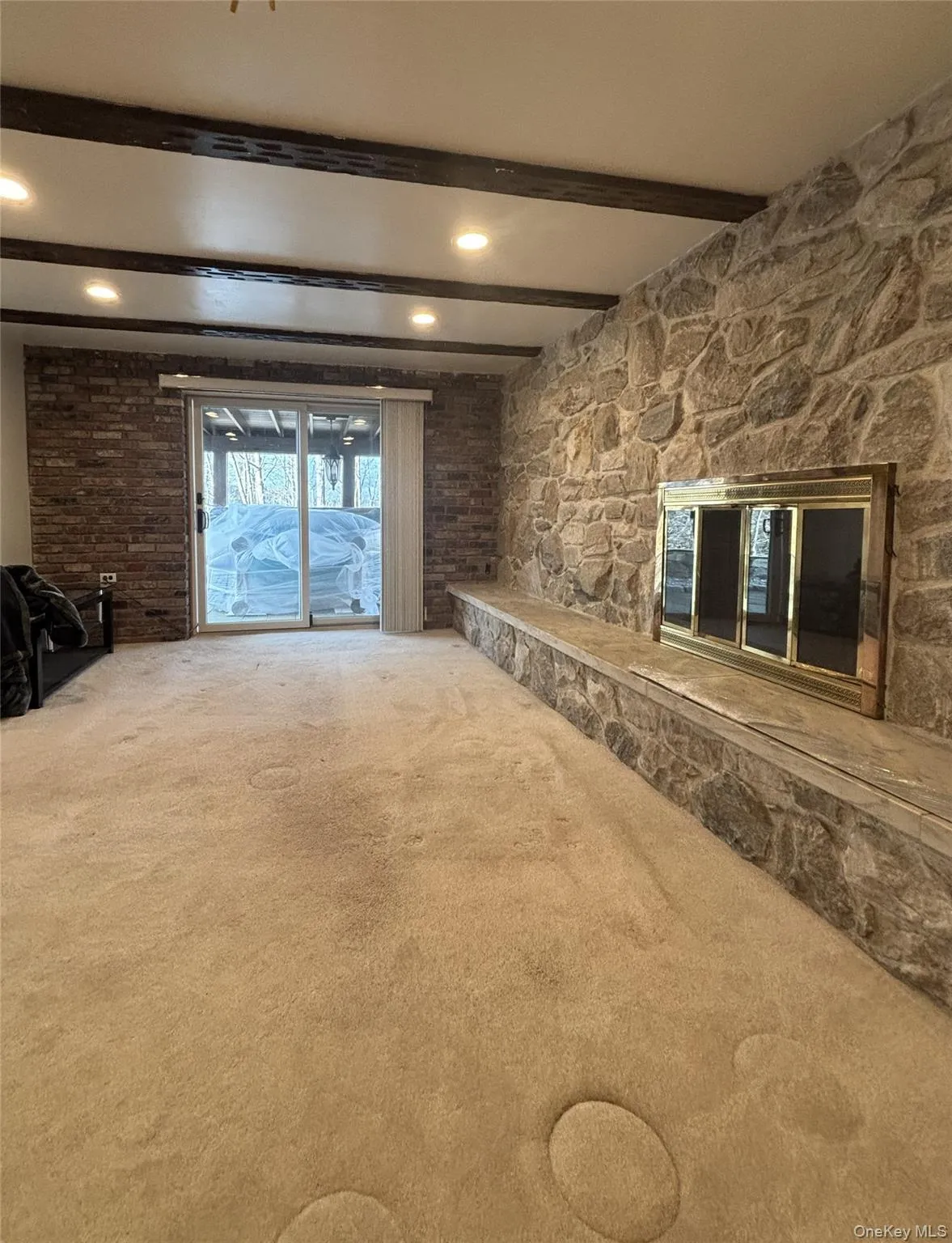 living room with beamed ceiling and carpet flooring living room with beamed ceiling and carpet flooring