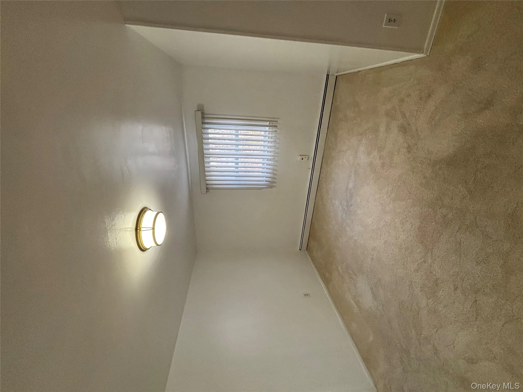 Empty room with light colored carpet and a baseboard heating unit Empty room with light colored carpet and a baseboard heating unit