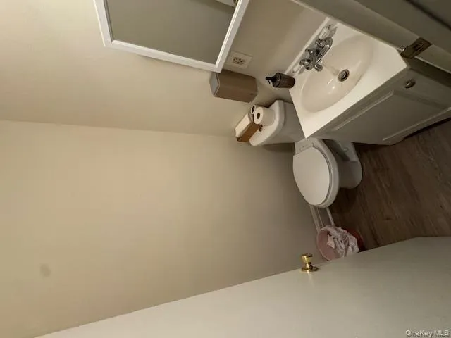 Half bathroom with dark wood finished floors and vanity Half bathroom with dark wood finished floors and vanity