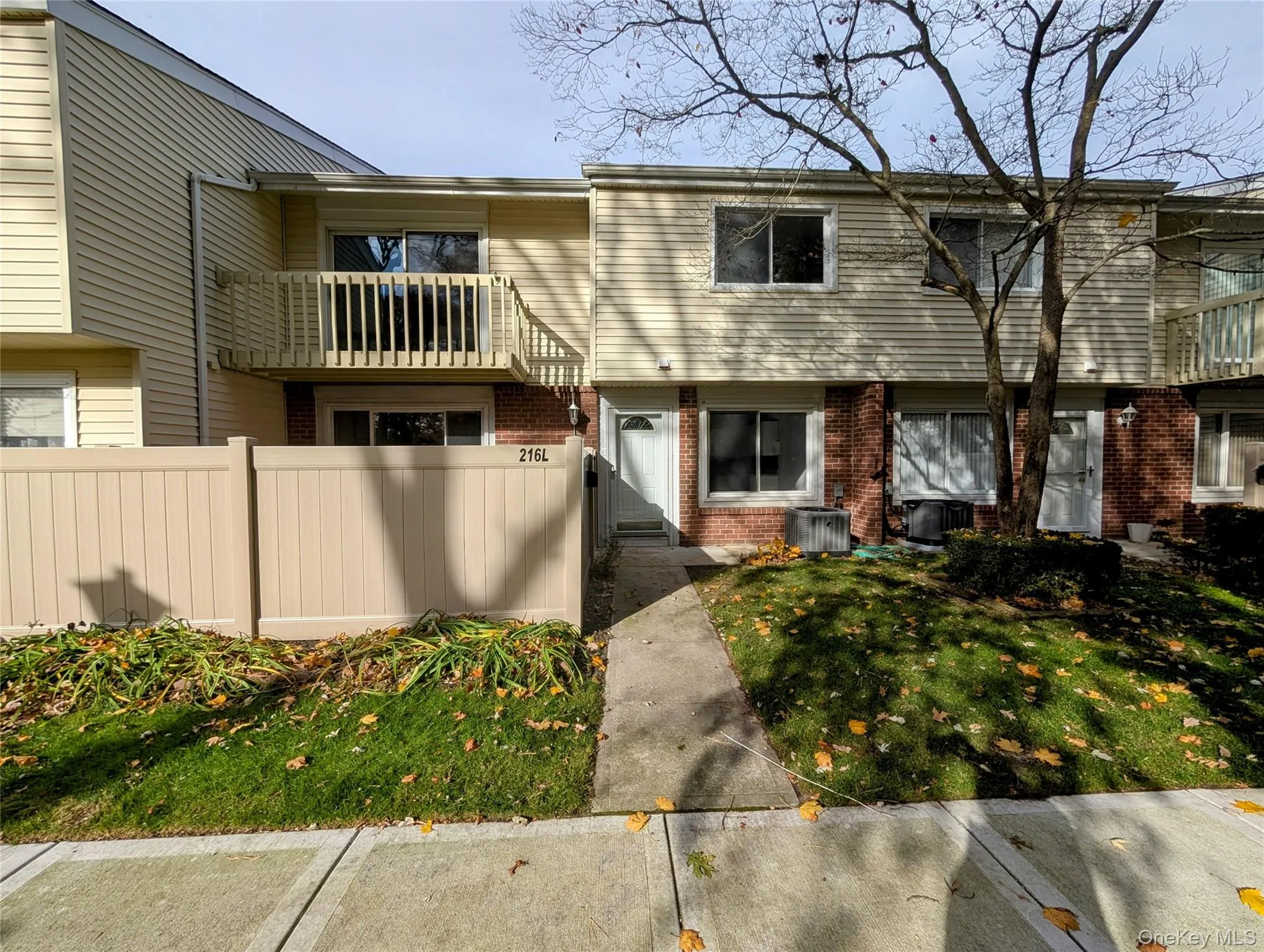 View of front of home with brick siding and a balcony View of front of home with brick siding and a balcony