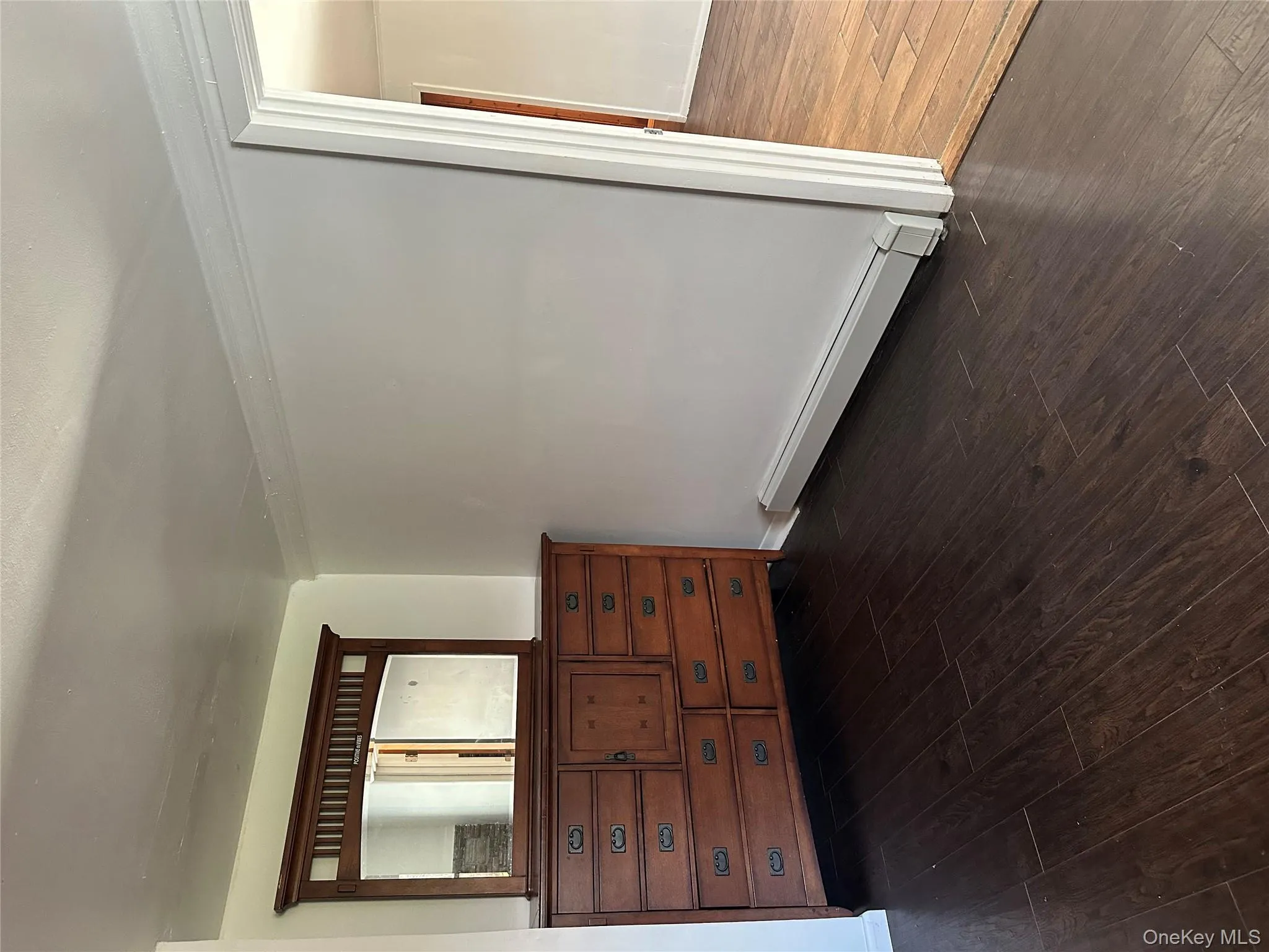 Bedroom featuring a baseboard heating unit and dark wood-style flooring Bedroom featuring a baseboard heating unit and dark wood-style flooring