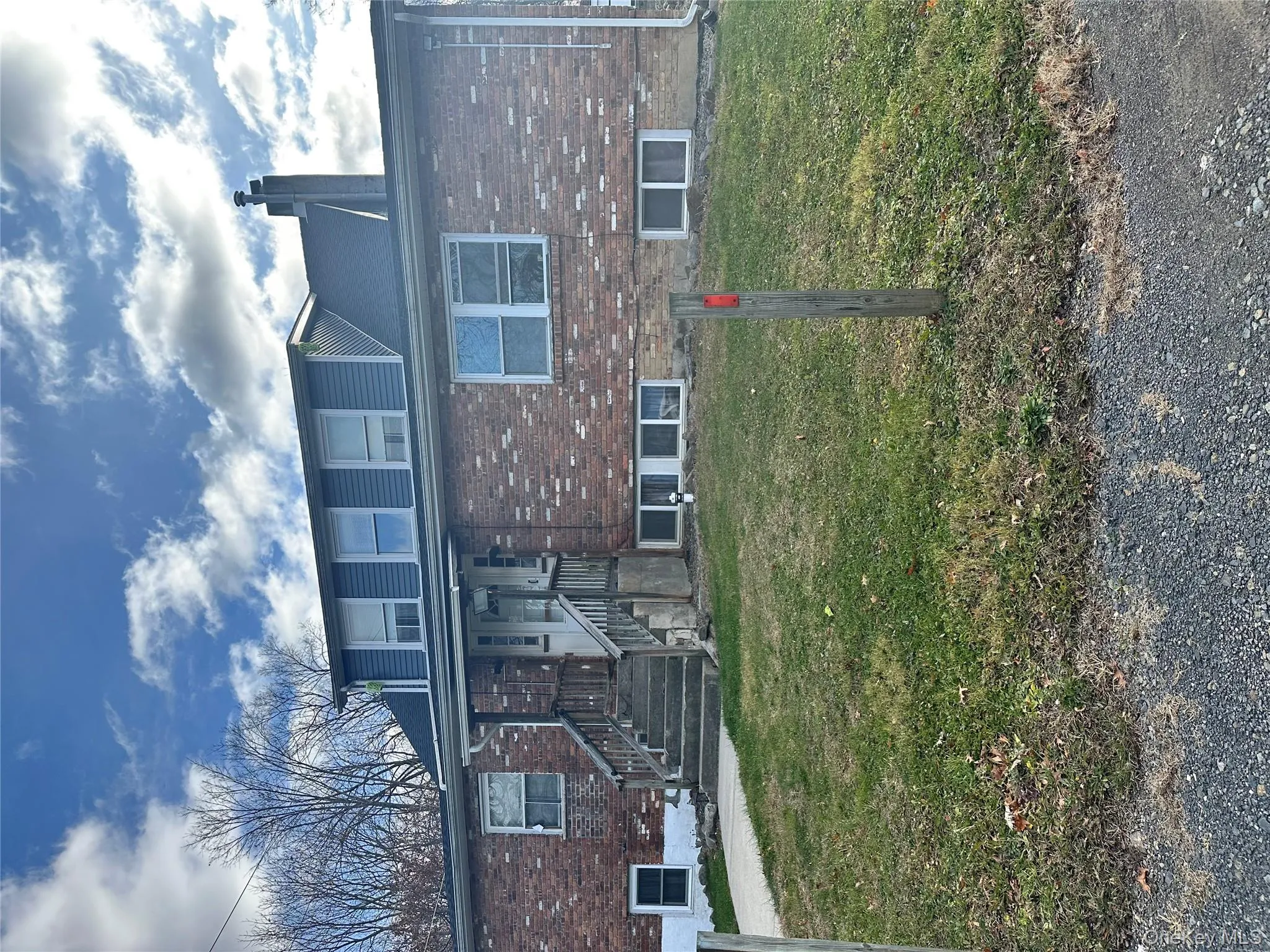View of front of property with brick siding, a front lawn, and a chimney View of front of property with brick siding, a front lawn, and a chimney