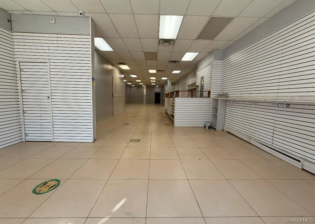 Corridor with a drop ceiling and light tile patterned flooring Corridor with a drop ceiling and light tile patterned flooring