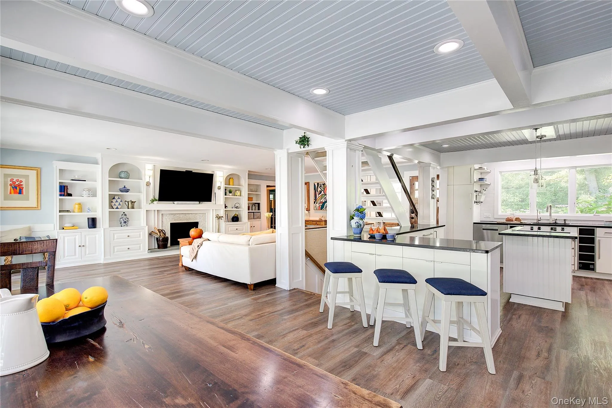 Living area featuring beam ceiling, stairs, dark wood-style floors, a fireplace, and recessed lighting Living area featuring beam ceiling, stairs, dark wood-style floors, a fireplace, and recessed lighting