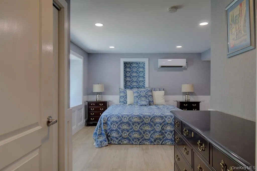 Bedroom with light wood-style flooring, recessed lighting, and a wall unit AC Bedroom with light wood-style flooring, recessed lighting, and a wall unit AC
