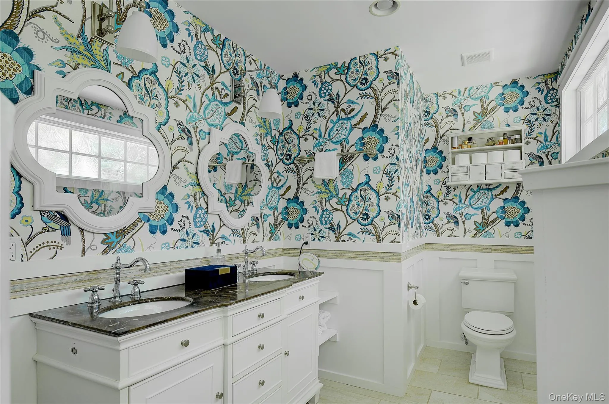 Full bath with wallpapered walls, double vanity, and light tile patterned floors Full bath with wallpapered walls, double vanity, and light tile patterned floors