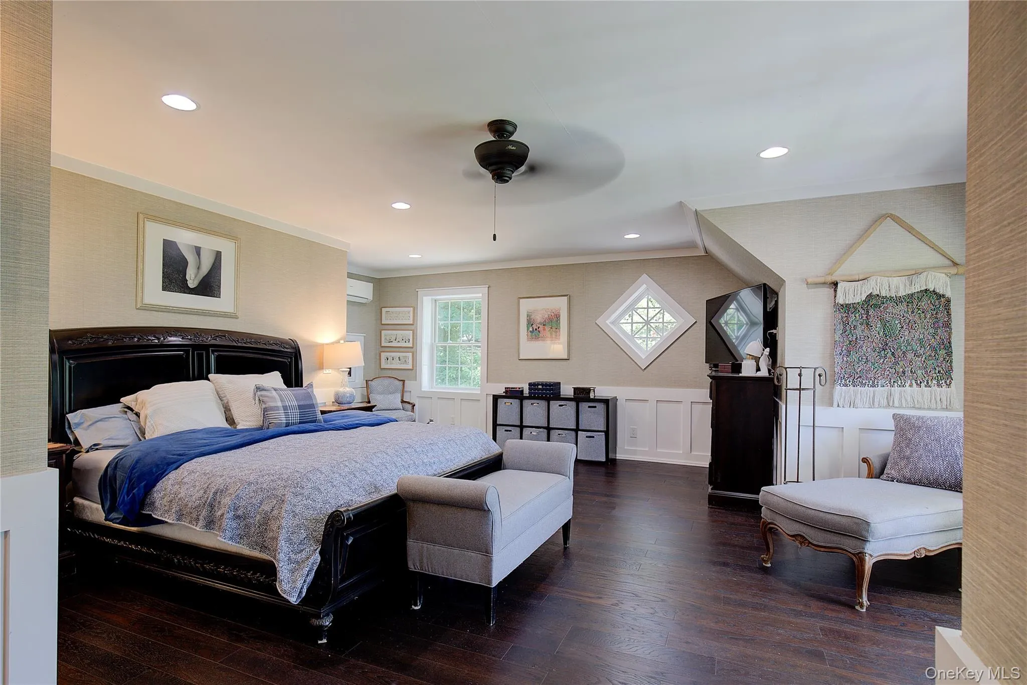 Bedroom featuring wallpapered walls, wainscoting, a ceiling fan, hardwood / wood-style flooring, and recessed lighting Bedroom featuring wallpapered walls, wainscoting, a ceiling fan, hardwood / wood-style flooring, and recessed lighting