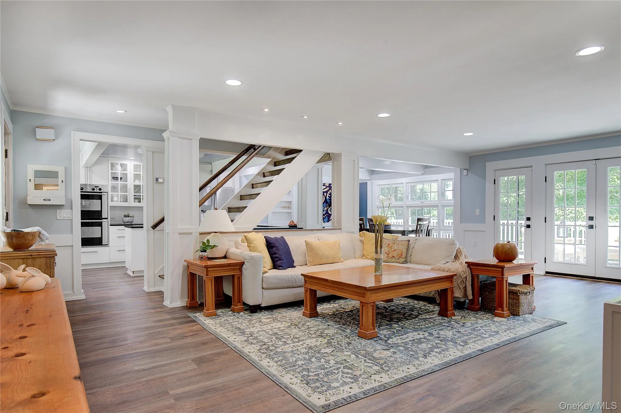 Living area featuring recessed lighting, wood finished floors, french doors, stairs, and a wainscoted wall Living area featuring recessed lighting, wood finished floors, french doors, stairs, and a wainscoted wall