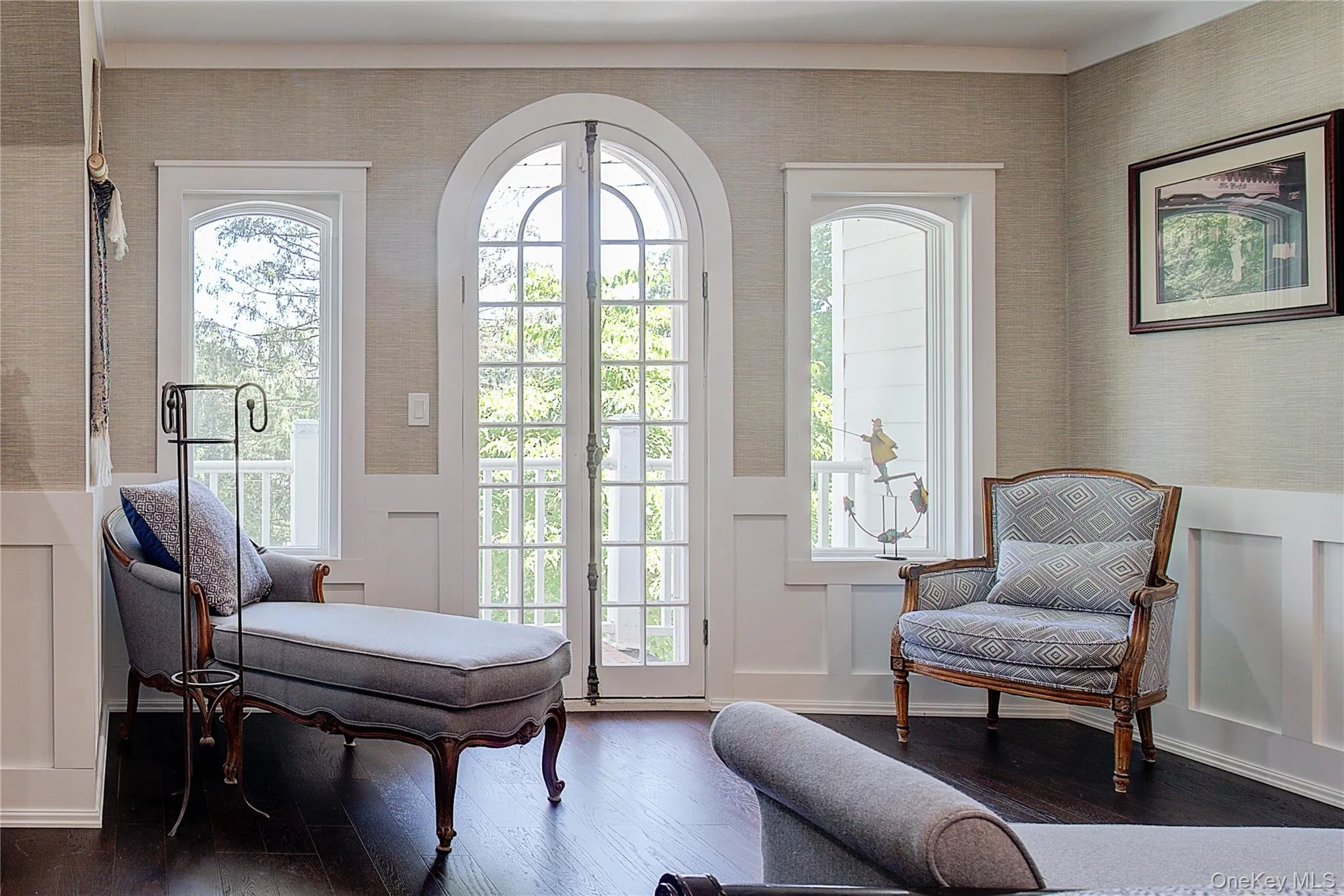 Living area featuring wallpapered walls, wood-type flooring, a decorative wall, and a wainscoted wall Living area featuring wallpapered walls, wood-type flooring, a decorative wall, and a wainscoted wall