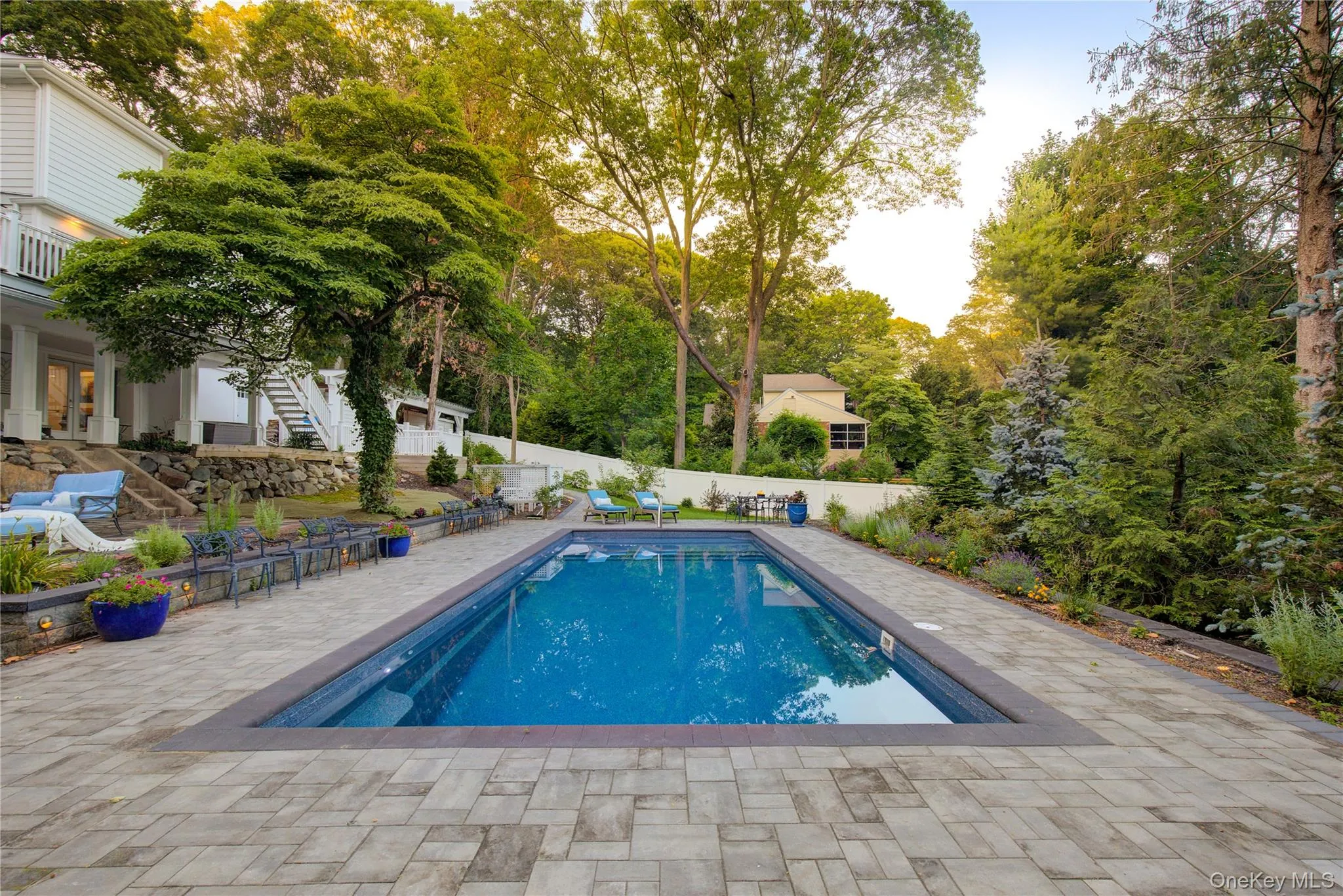 View of swimming pool featuring stairway, a patio area, view of wooded area, and a fenced backyard View of swimming pool featuring stairway, a patio area, view of wooded area, and a fenced backyard