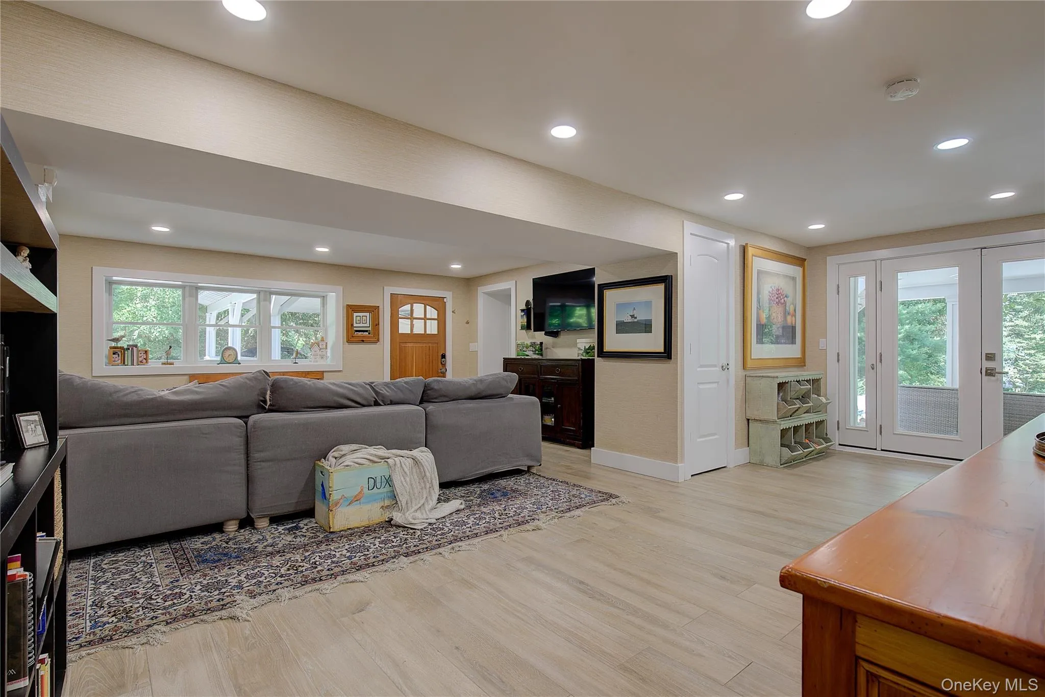 Living room featuring recessed lighting, light wood-style floors, and french doors Living room featuring recessed lighting, light wood-style floors, and french doors