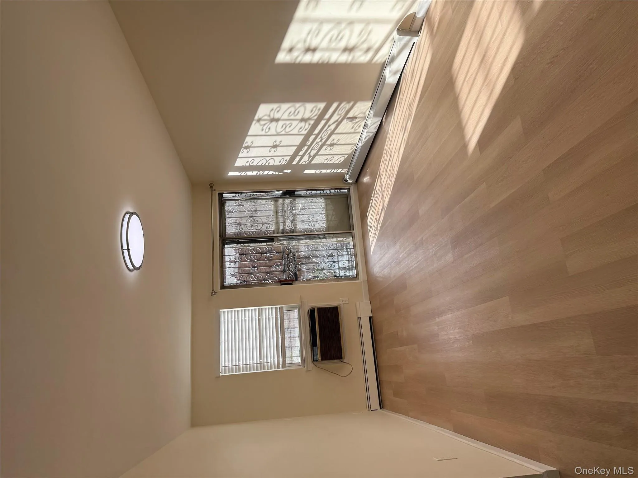 Unfurnished living room with a baseboard heating unit and light wood-style floors Unfurnished living room with a baseboard heating unit and light wood-style floors