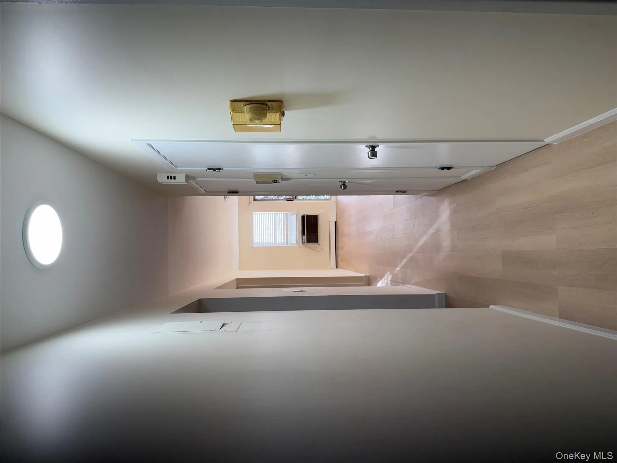 Corridor featuring light wood-type flooring and baseboard heating Corridor featuring light wood-type flooring and baseboard heating