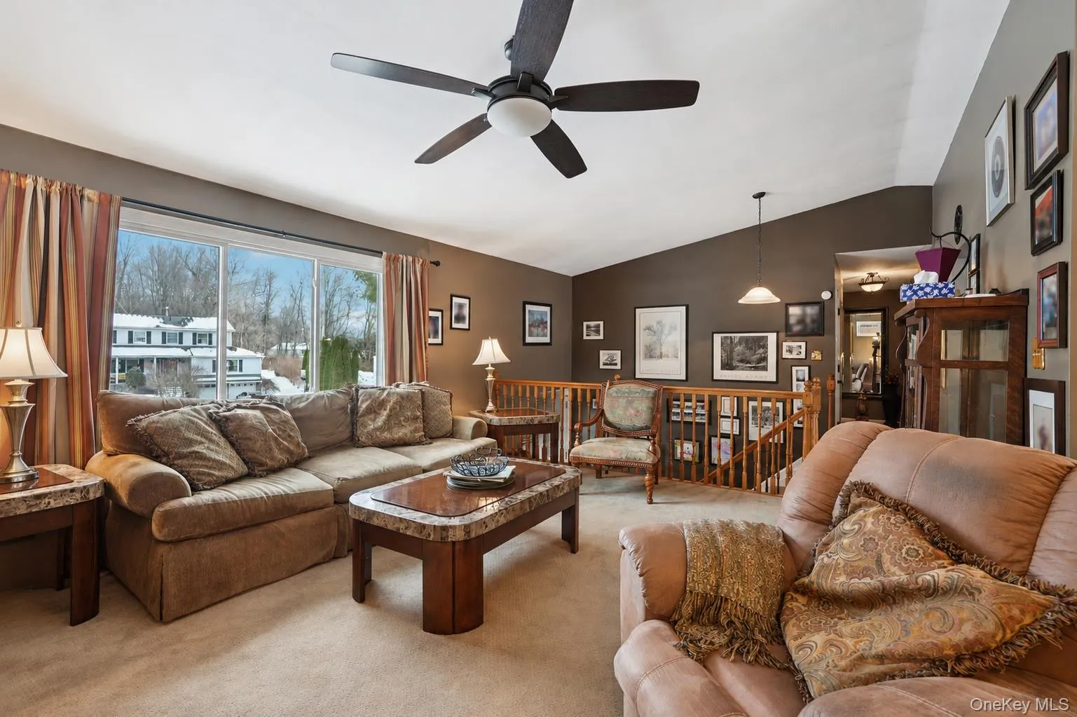 Living area featuring carpet, lofted ceiling, and a ceiling fan. some photos may include virtually staged or digitally modified Living area featuring carpet, lofted ceiling, and a ceiling fan. some photos may include virtually staged or digitally modified