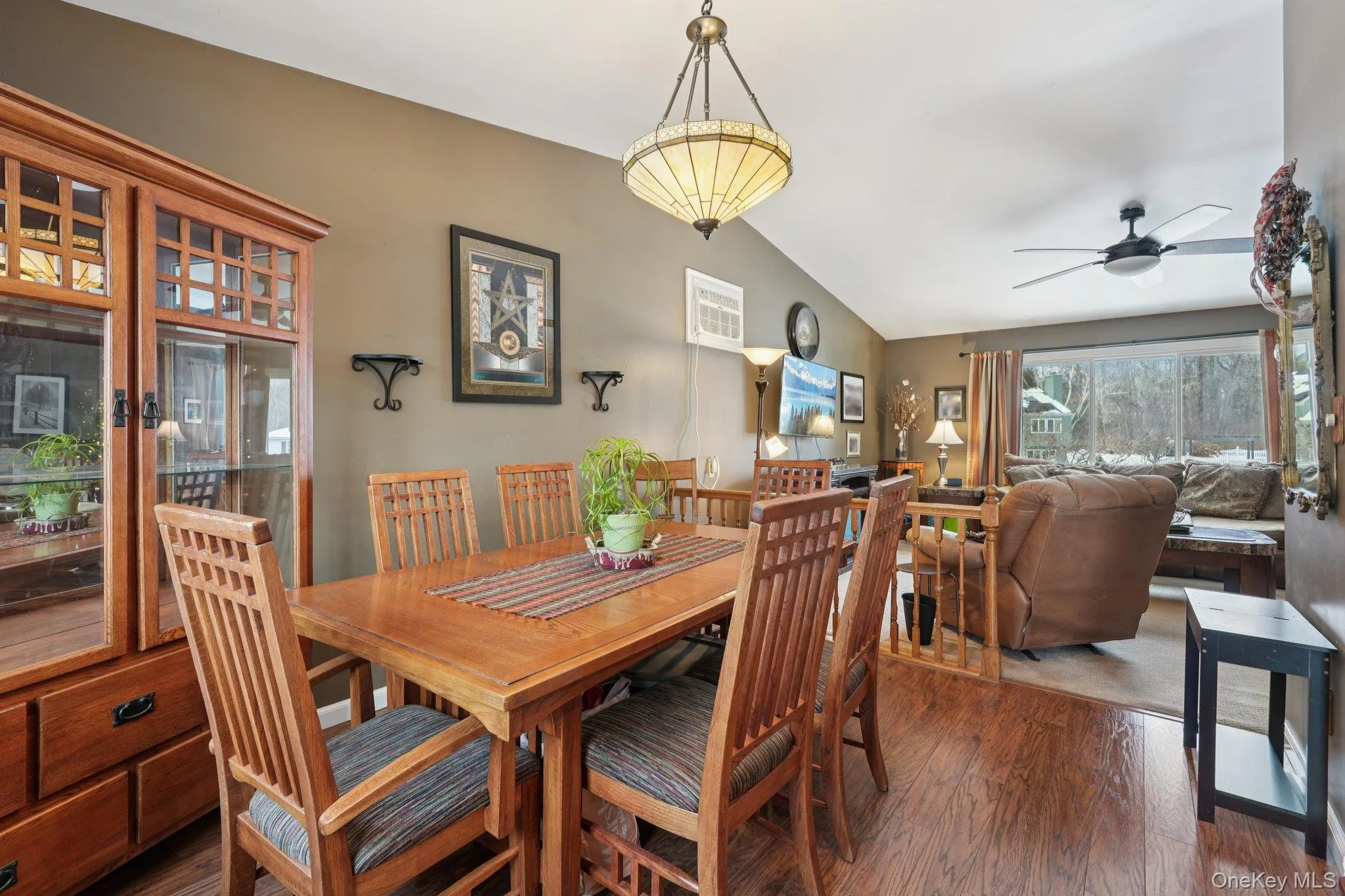 Dining space with vaulted ceiling, a ceiling fan, and wood finished floors. some photos may include virtually staged or digitally modified Dining space with vaulted ceiling, a ceiling fan, and wood finished floors. some photos may include virtually staged or digitally modified