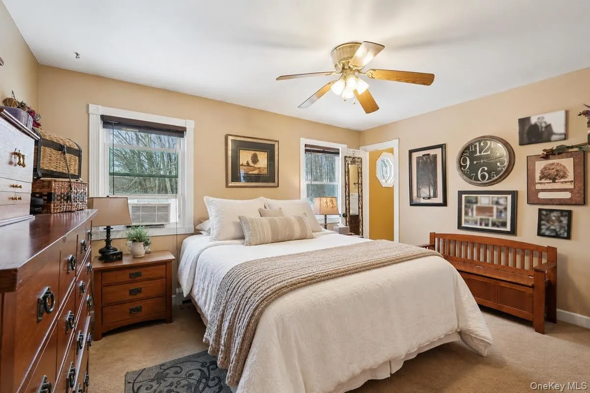 Primary Bedroom featuring light carpet, a ceiling fan, and baseboard heating.some photos may include virtually staged or digitally modified Primary Bedroom featuring light carpet, a ceiling fan, and baseboard heating.some photos may include virtually staged or digitally modified