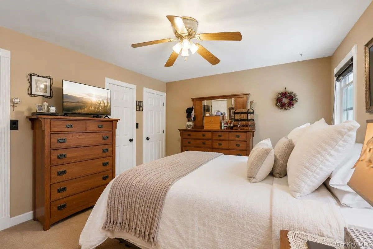Bedroom with light tan wall finish, white trim, and a ceiling fan light fixture. some photos may include virtually staged or digitally modified Bedroom with light tan wall finish, white trim, and a ceiling fan light fixture. some photos may include virtually staged or digitally modified