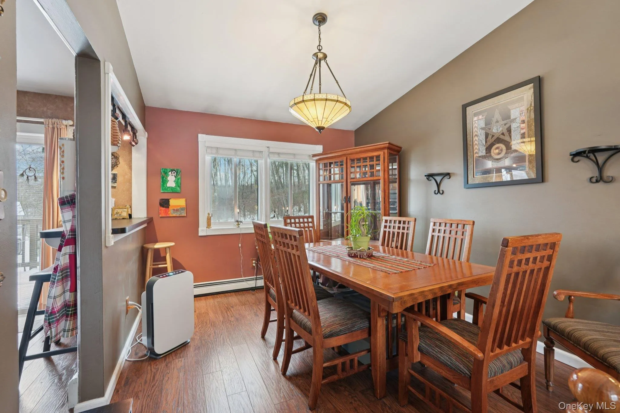 Dining room featuring hardwood / wood-style flooring and baseboard heating. some photos may include virtually staged or digitally modified Dining room featuring hardwood / wood-style flooring and baseboard heating. some photos may include virtually staged or digitally modified