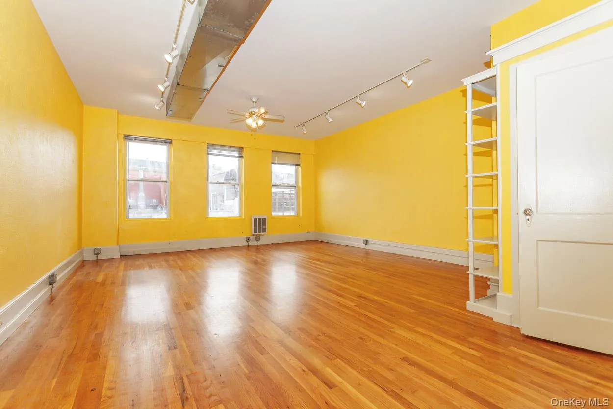 Spare room featuring rail lighting, light wood-type flooring, and a ceiling fan Spare room featuring rail lighting, light wood-type flooring, and a ceiling fan