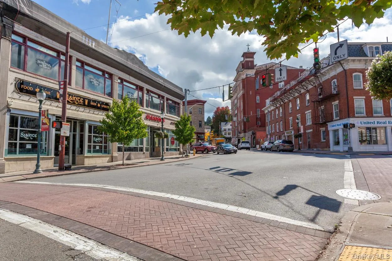 View of asphalt road featuring sidewalks, street lights, and curbs View of asphalt road featuring sidewalks, street lights, and curbs