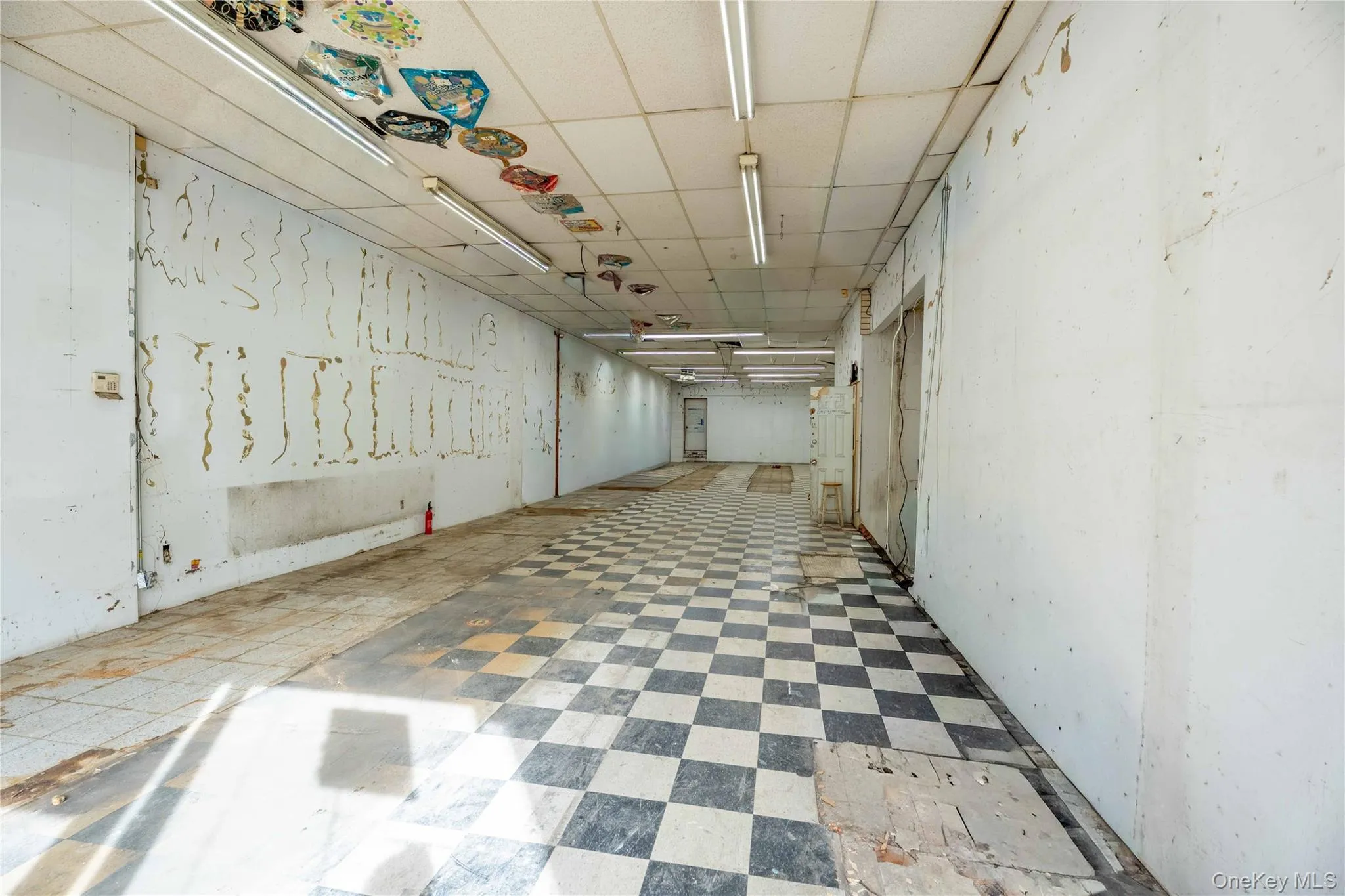 Below grade area featuring tile patterned floors and a drop ceiling Below grade area featuring tile patterned floors and a drop ceiling