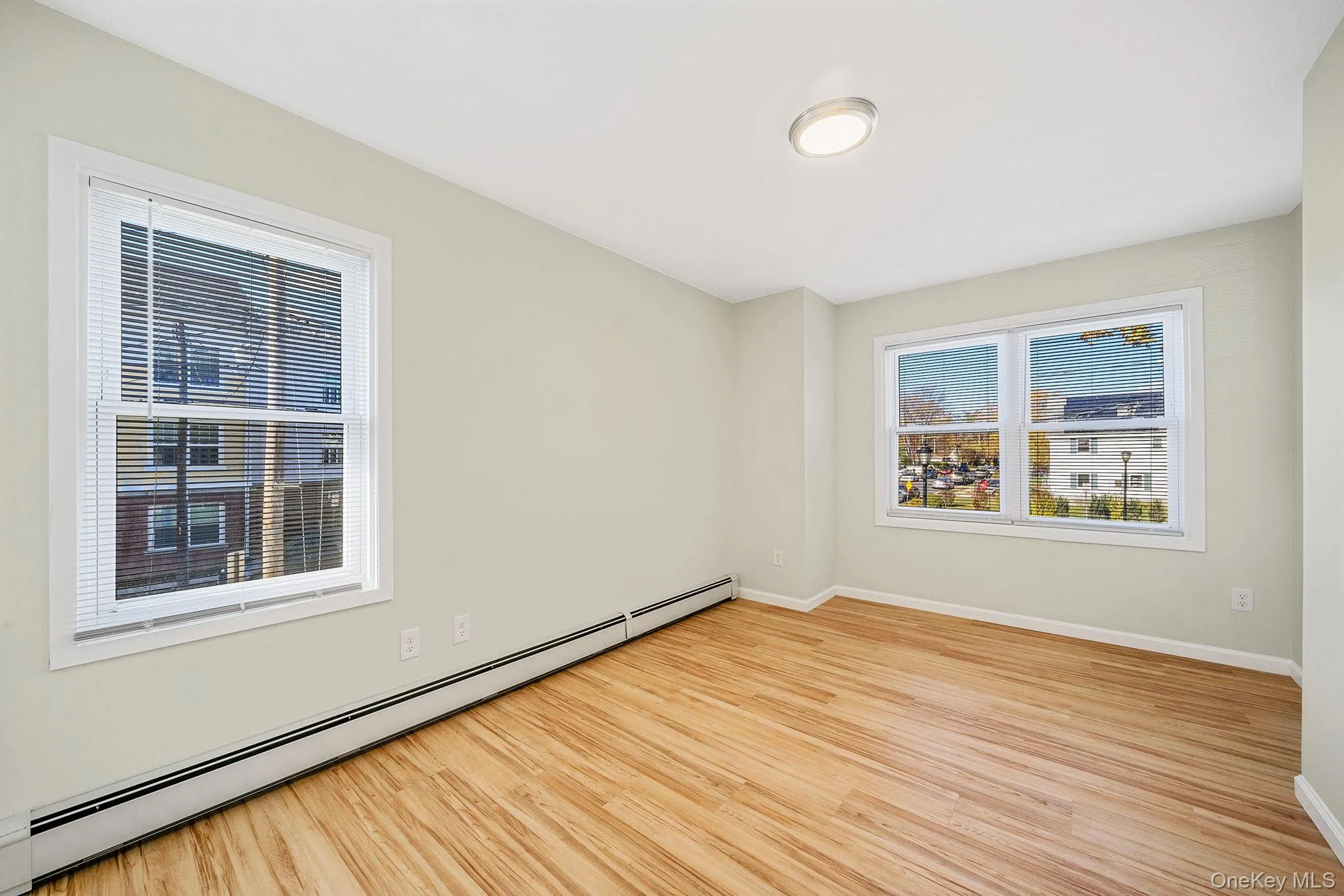 Spare room featuring a baseboard radiator and light wood-style floors Spare room featuring a baseboard radiator and light wood-style floors