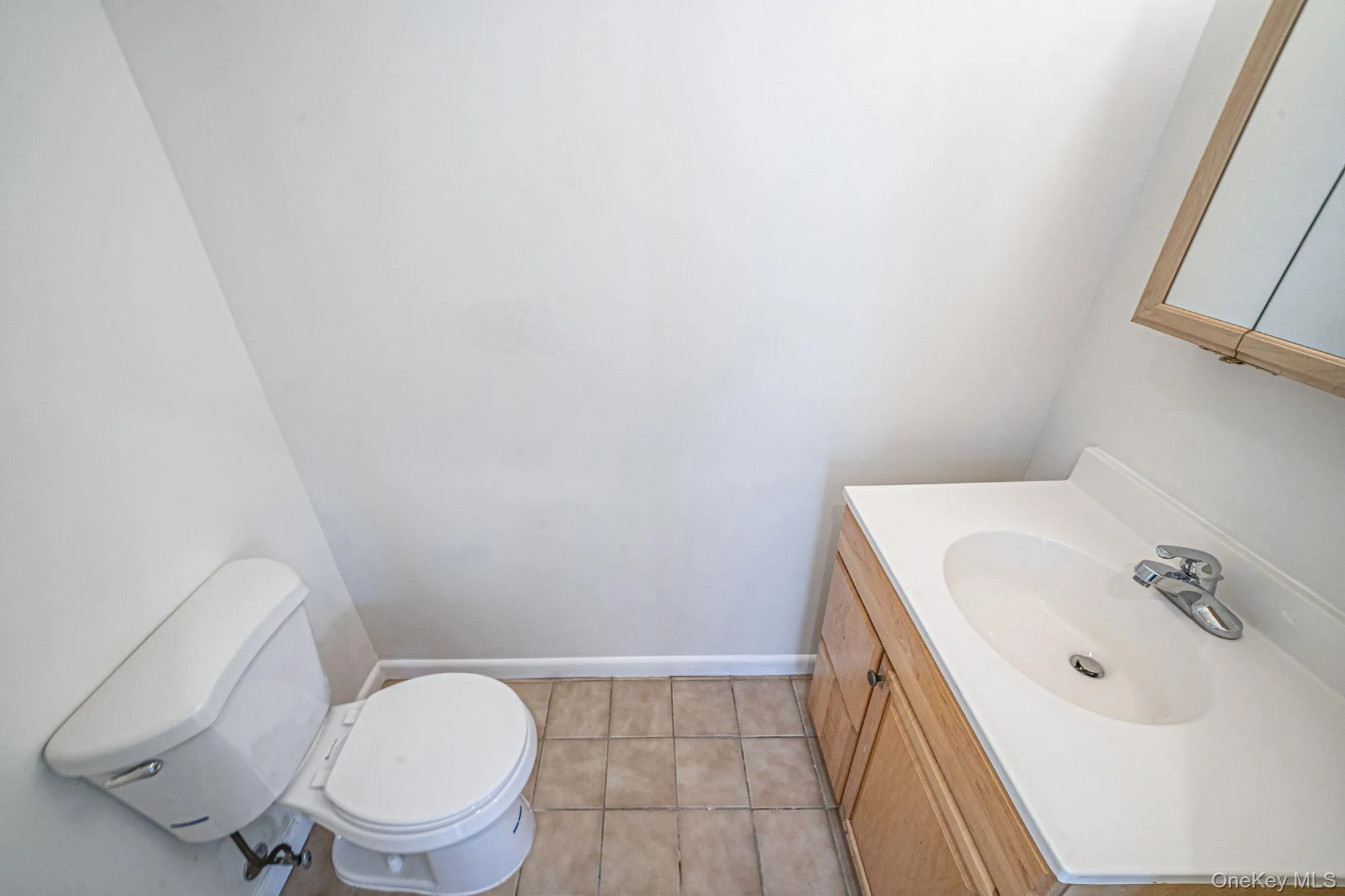 Half bathroom with vanity and light tile patterned flooring Half bathroom with vanity and light tile patterned flooring