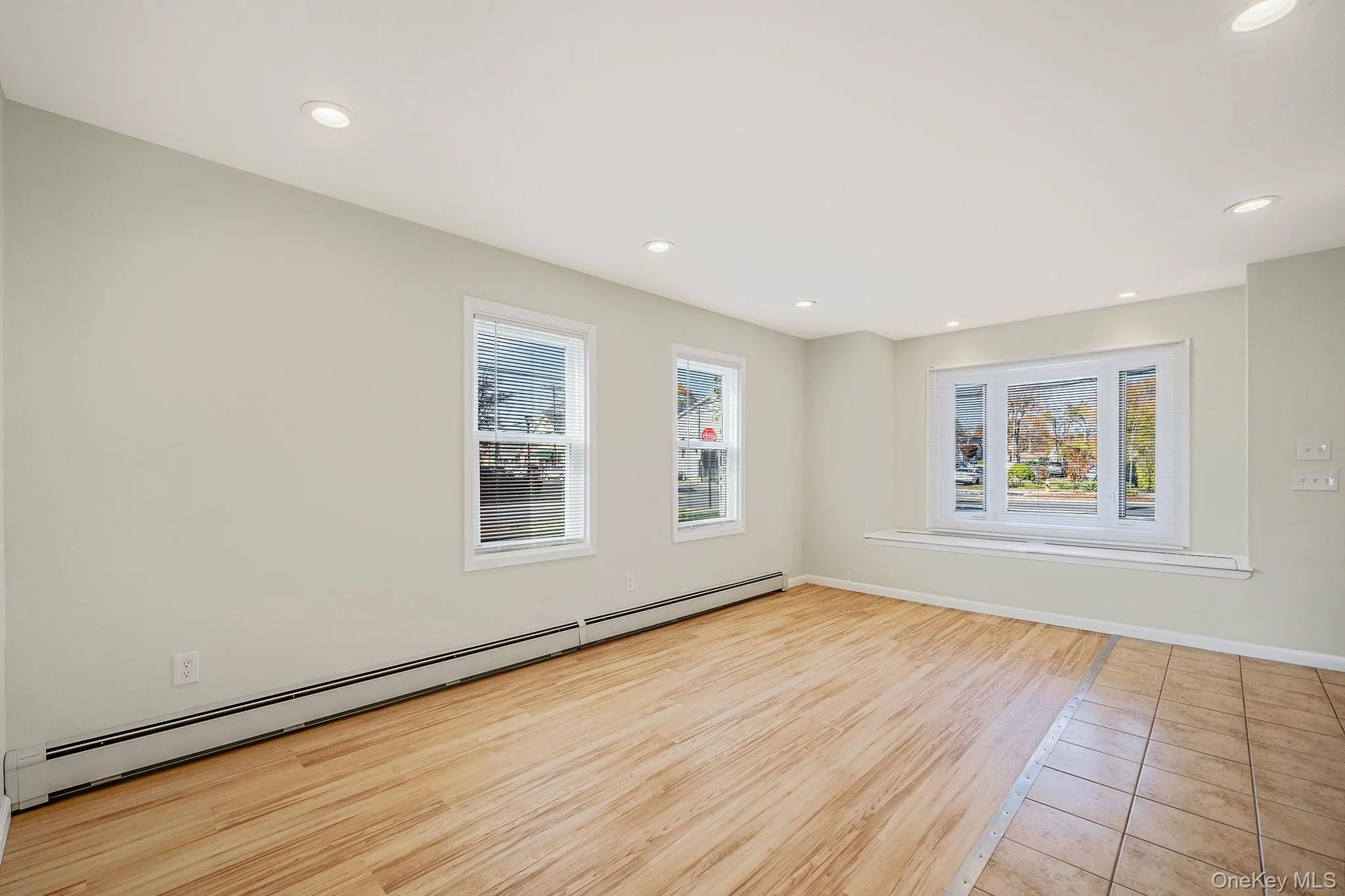 Spare room featuring baseboard heating, plenty of natural light, light wood-style floors, and recessed lighting Spare room featuring baseboard heating, plenty of natural light, light wood-style floors, and recessed lighting