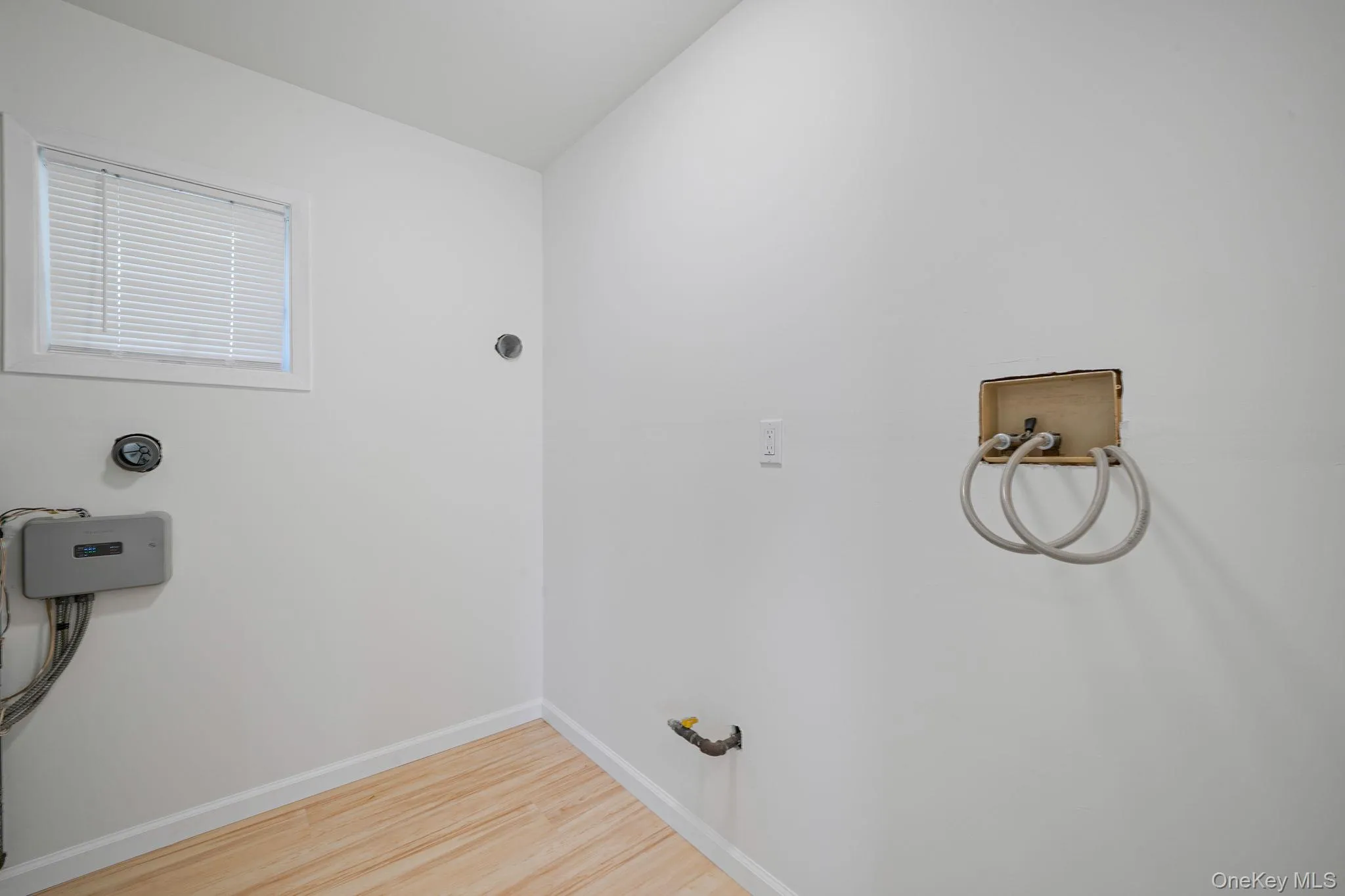 Washroom with washer hookup and wood finished floors Washroom with washer hookup and wood finished floors