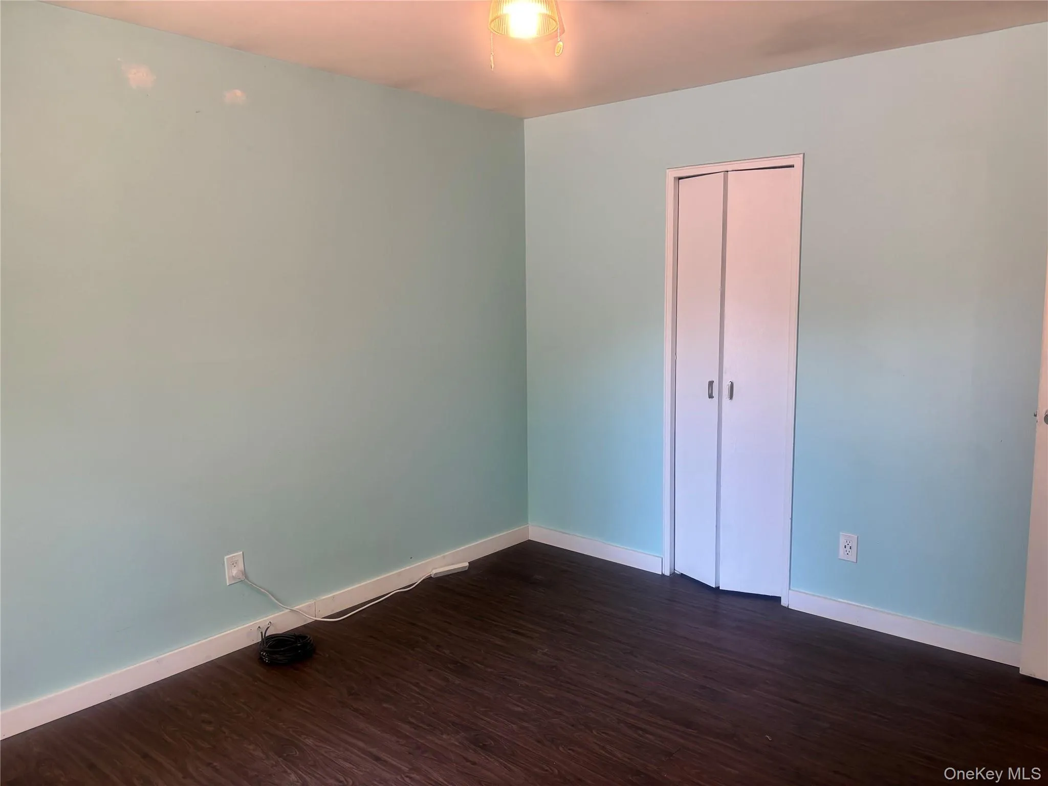 Empty room featuring dark wood finished floors and baseboards Empty room featuring dark wood finished floors and baseboards