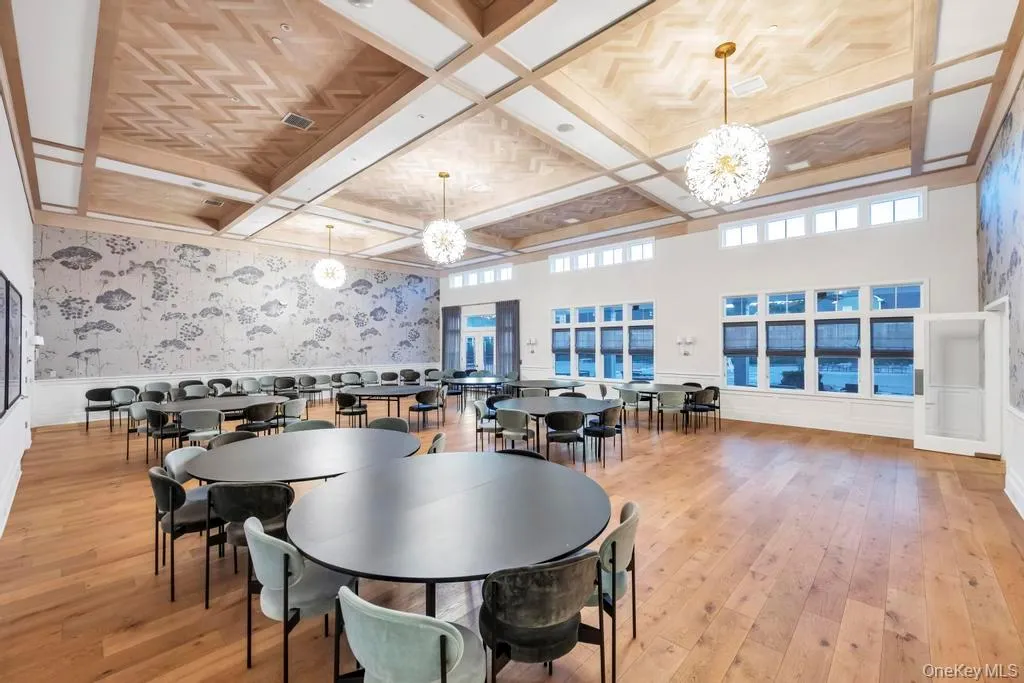 Dining room with wallpapered walls, wainscoting, coffered ceiling, light wood-type flooring, and beam ceiling Dining room with wallpapered walls, wainscoting, coffered ceiling, light wood-type flooring, and beam ceiling