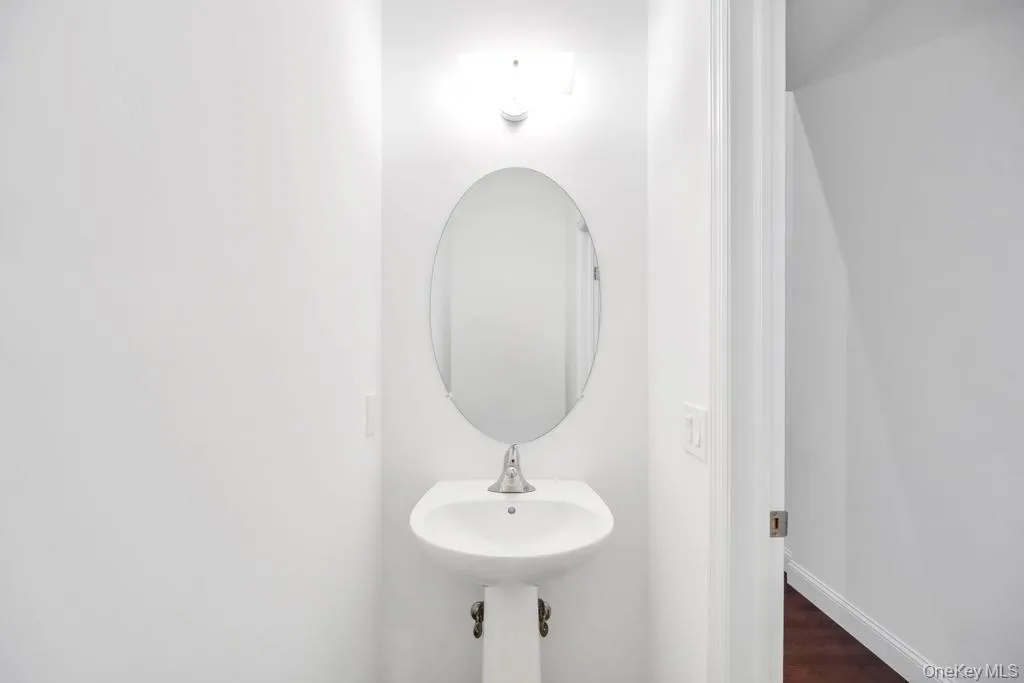 Half Bathroom featuring dark wood-type flooring and baseboards Half Bathroom featuring dark wood-type flooring and baseboards