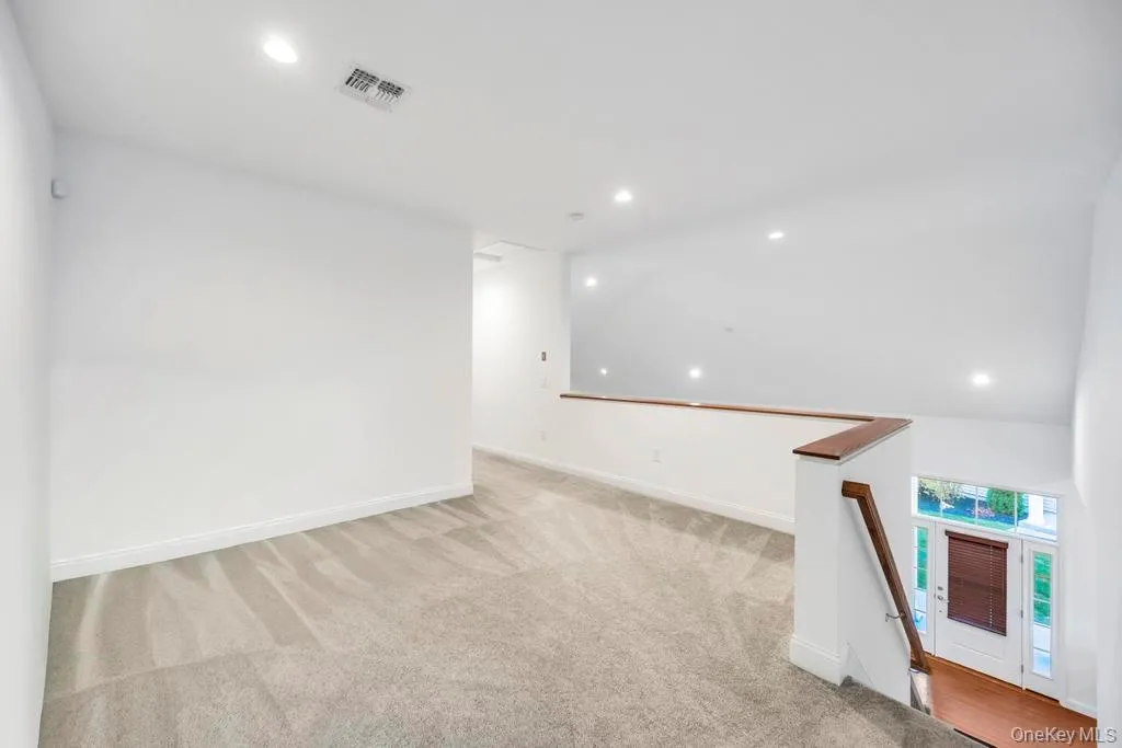 Spare room with recessed lighting, light colored carpet, and vaulted ceiling Spare room with recessed lighting, light colored carpet, and vaulted ceiling