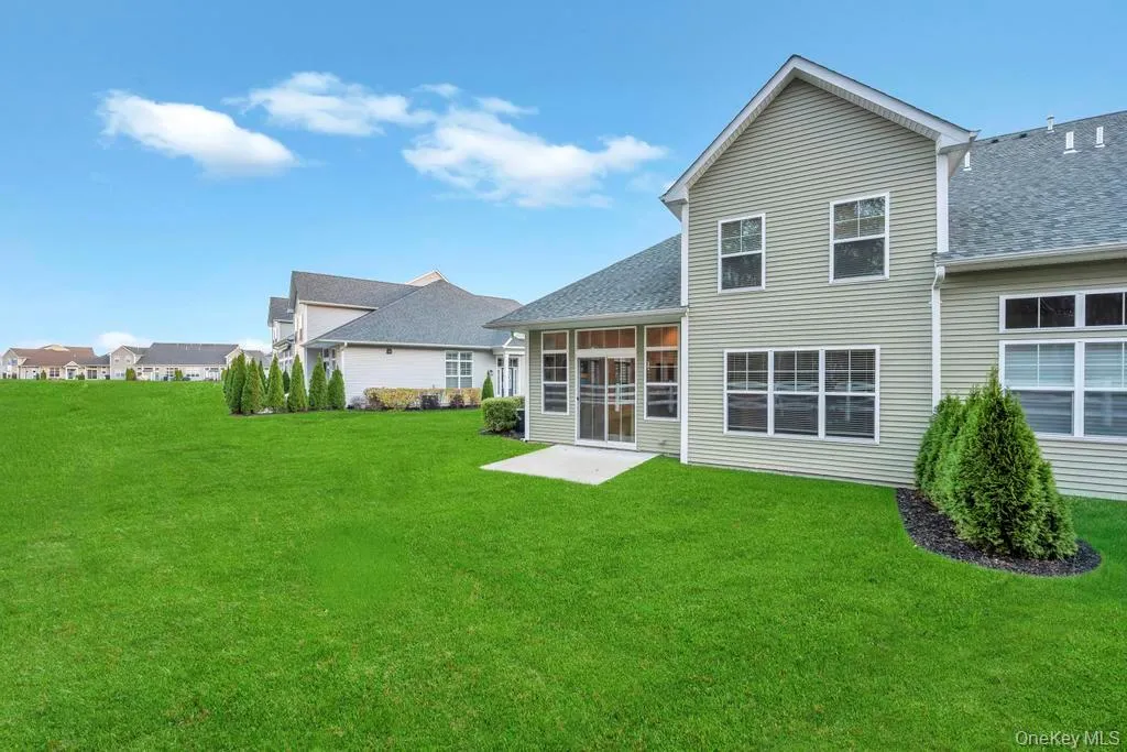 Rear view of house featuring a lawn, a sunroom, and a shingled roof Rear view of house featuring a lawn, a sunroom, and a shingled roof