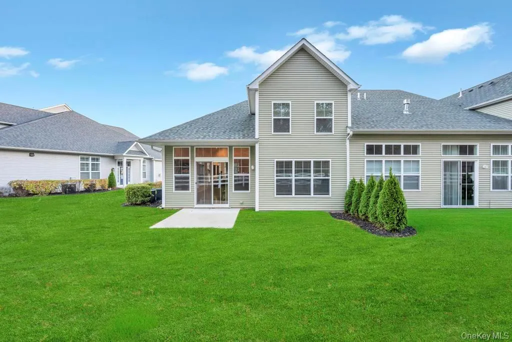 Rear view of house featuring a lawn, a shingled roof, and a patio Rear view of house featuring a lawn, a shingled roof, and a patio