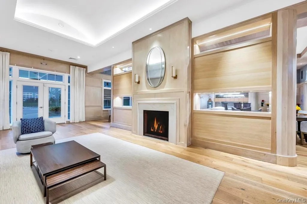Living area featuring french doors, hardwood / wood-style flooring, a premium fireplace, and recessed lighting Living area featuring french doors, hardwood / wood-style flooring, a premium fireplace, and recessed lighting