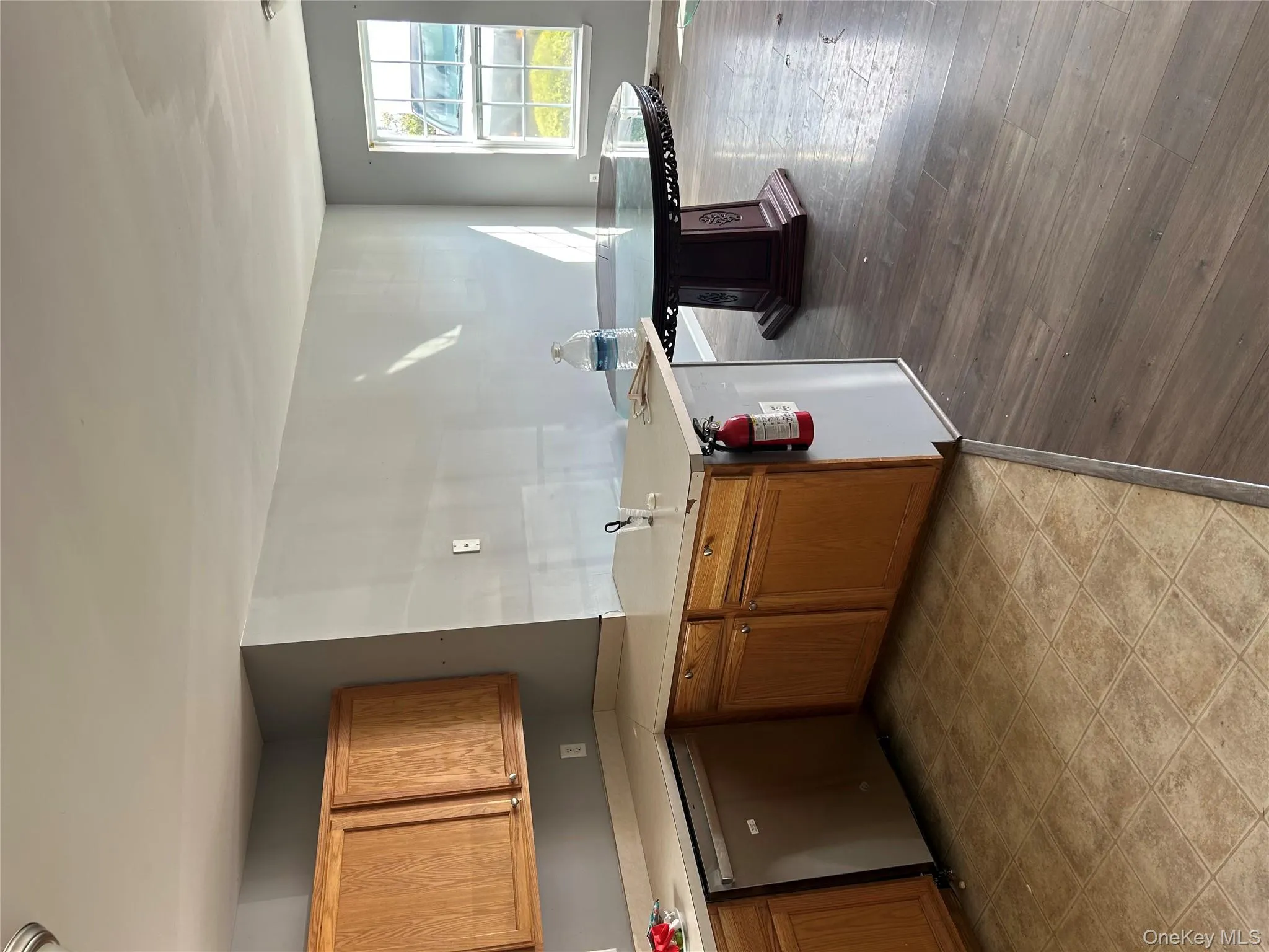 Kitchen featuring light countertops, dishwashing machine, brown cabinetry, a peninsula, and light wood-style floors Kitchen featuring light countertops, dishwashing machine, brown cabinetry, a peninsula, and light wood-style floors