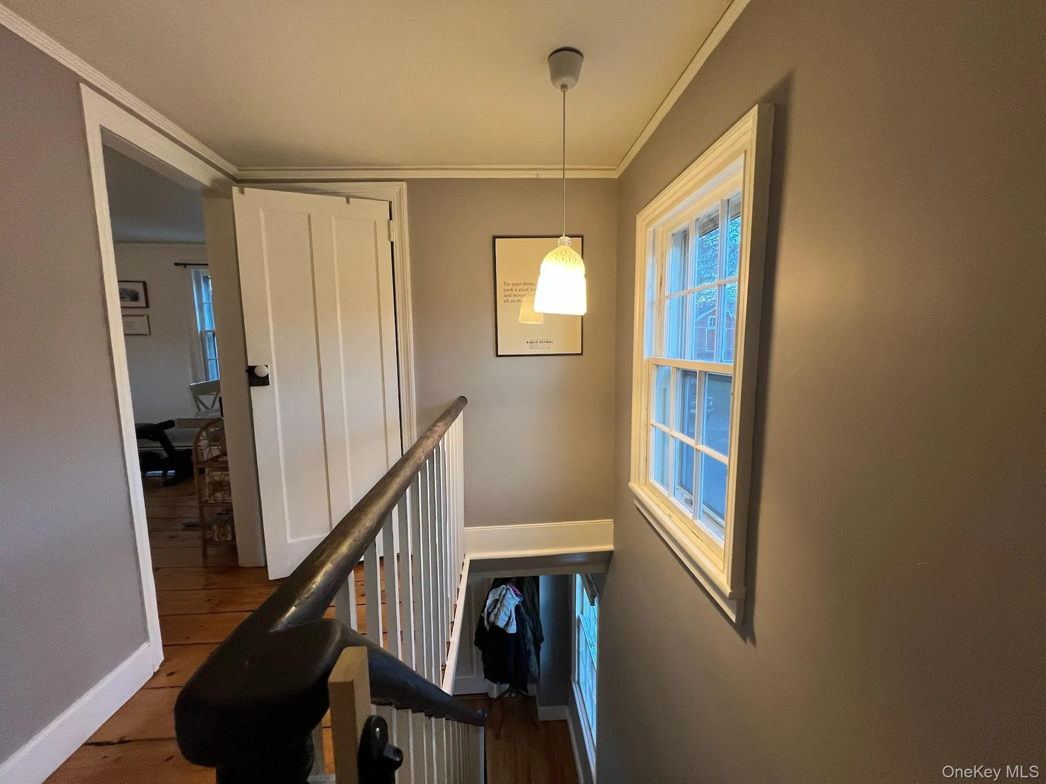 Stairway featuring wood finished floors and ornamental molding Stairway featuring wood finished floors and ornamental molding