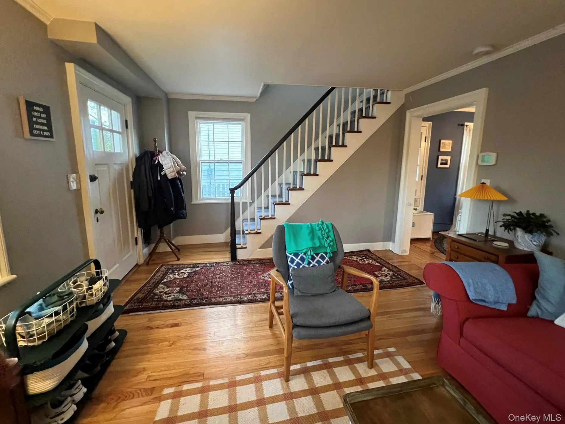Living area with ornamental molding, stairs, and light wood-style flooring Living area with ornamental molding, stairs, and light wood-style flooring