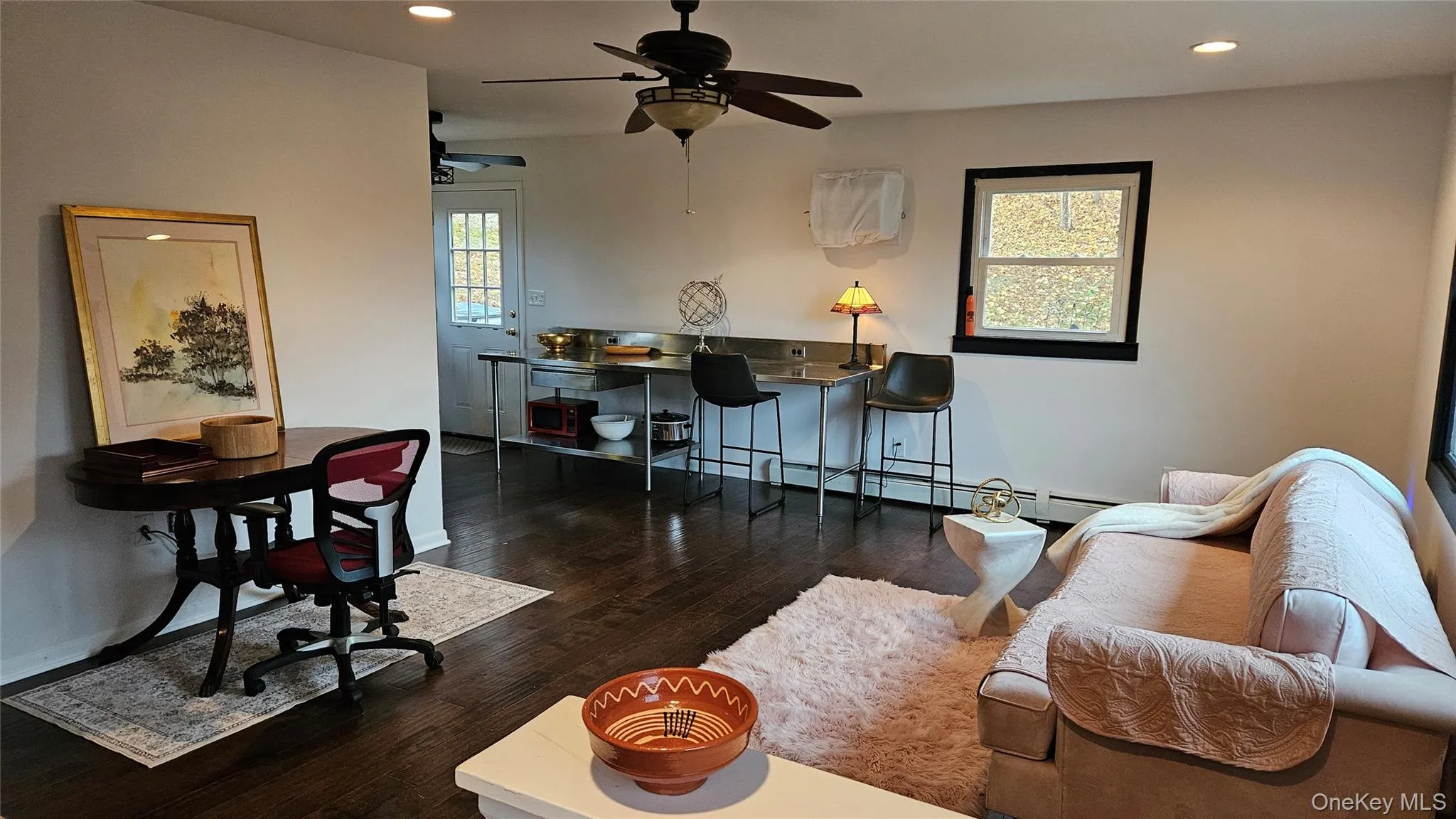 Living room featuring recessed lighting, dark wood finished floors, ceiling fan, and a baseboard heating unit Living room featuring recessed lighting, dark wood finished floors, ceiling fan, and a baseboard heating unit