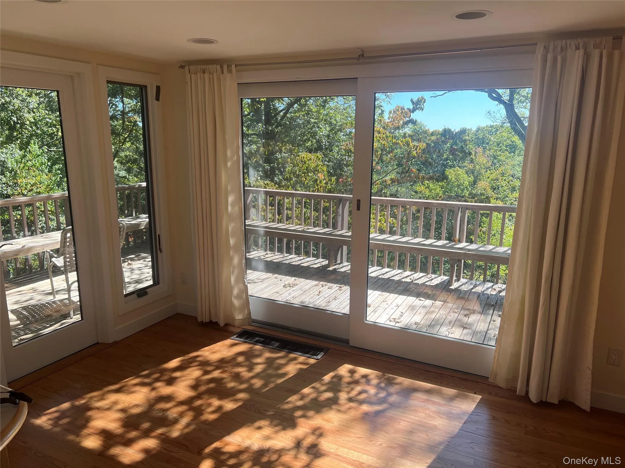 Doorway to outside featuring wood finished floors and view of wooded area Doorway to outside featuring wood finished floors and view of wooded area