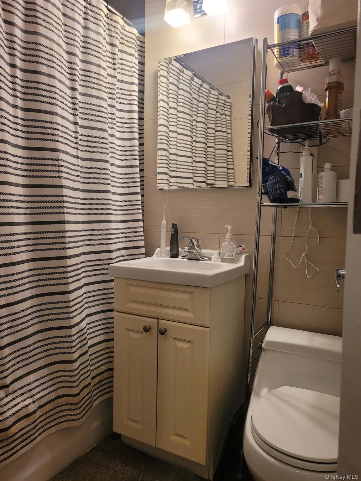 Full bathroom featuring vanity and curtained shower Full bathroom featuring vanity and curtained shower