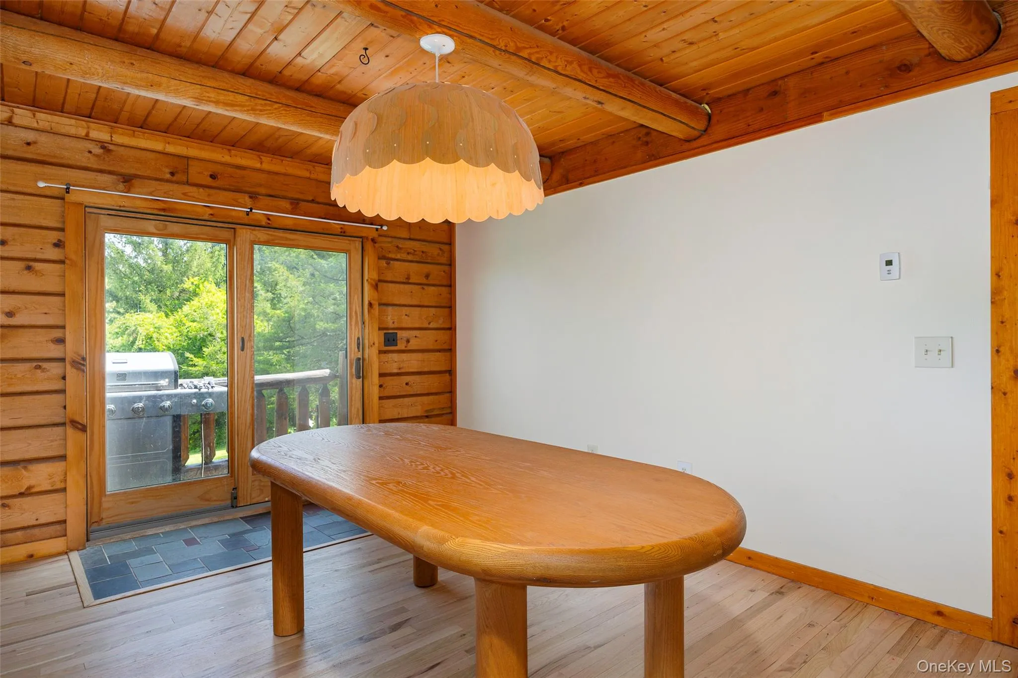 Dining space featuring light wood-style flooring and a wooden ceiling with exposed beams Dining space featuring light wood-style flooring and a wooden ceiling with exposed beams