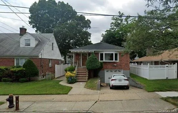 View of front of home with brick siding, driveway, an attached garage, and stairway View of front of home with brick siding, driveway, an attached garage, and stairway