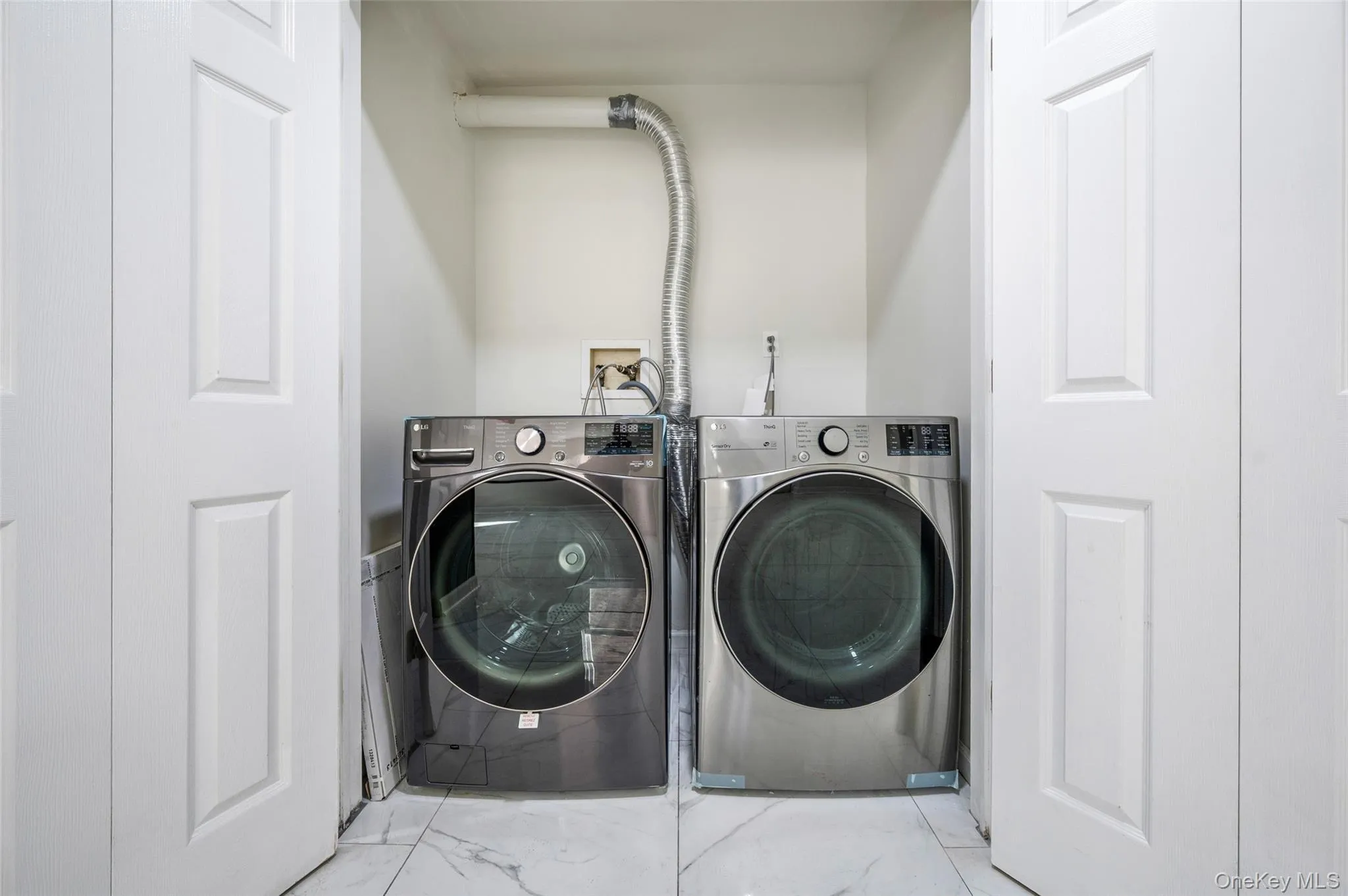 Laundry room with washing machine and clothes dryer and marble finish flooring Laundry room with washing machine and clothes dryer and marble finish flooring